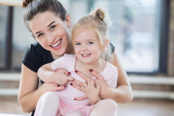 istock Adorable little ballerina smiles for camera with dance instructor 838910584