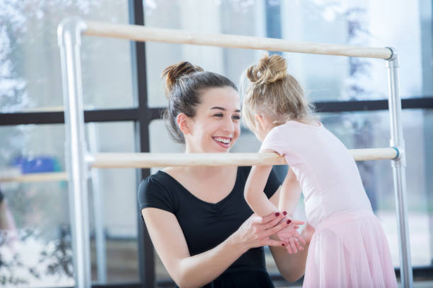 istock Ballet instructor works with preschool age student at ballet barre 838910586