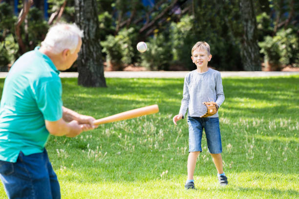 nipote e nonno che giocano a baseball - playing catch foto e immagini stock