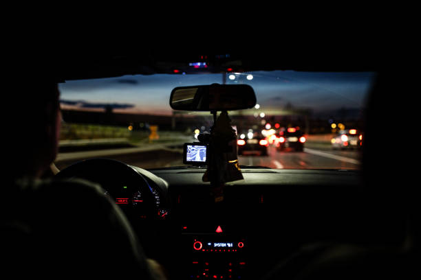 istock Man driving car through city streets at night 838917090