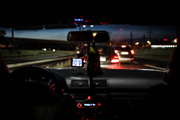 istock Man driving car through city streets at night 838917196