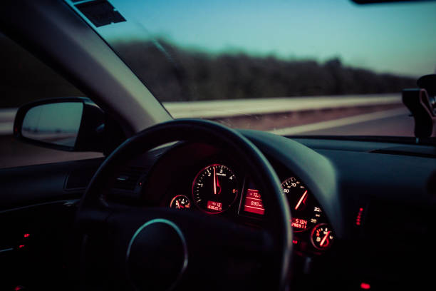 istock Man driving car through city streets at night 838917540