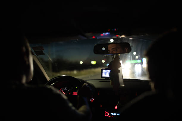 istock Man driving car through city streets at night 838918242