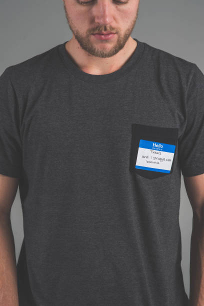 istock Man facing audience with name tag that describes struggle 