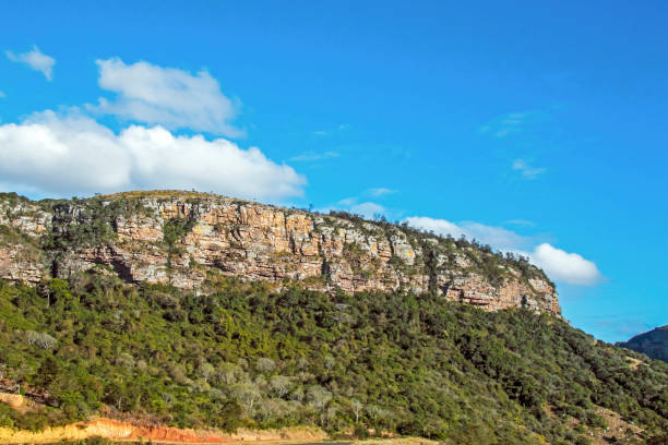istock Green Trees and Rock Cliffs Against Blue Cloudy Sky 838918454