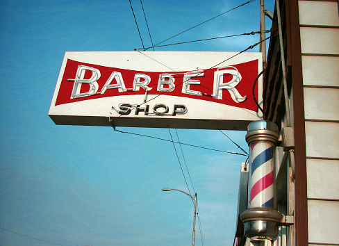 aged and worn vintage neon barber shop sign