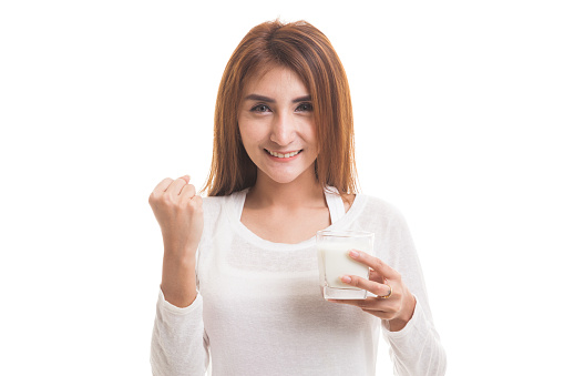 Healthy Asian woman drinking a glass of milk  isolated on white background