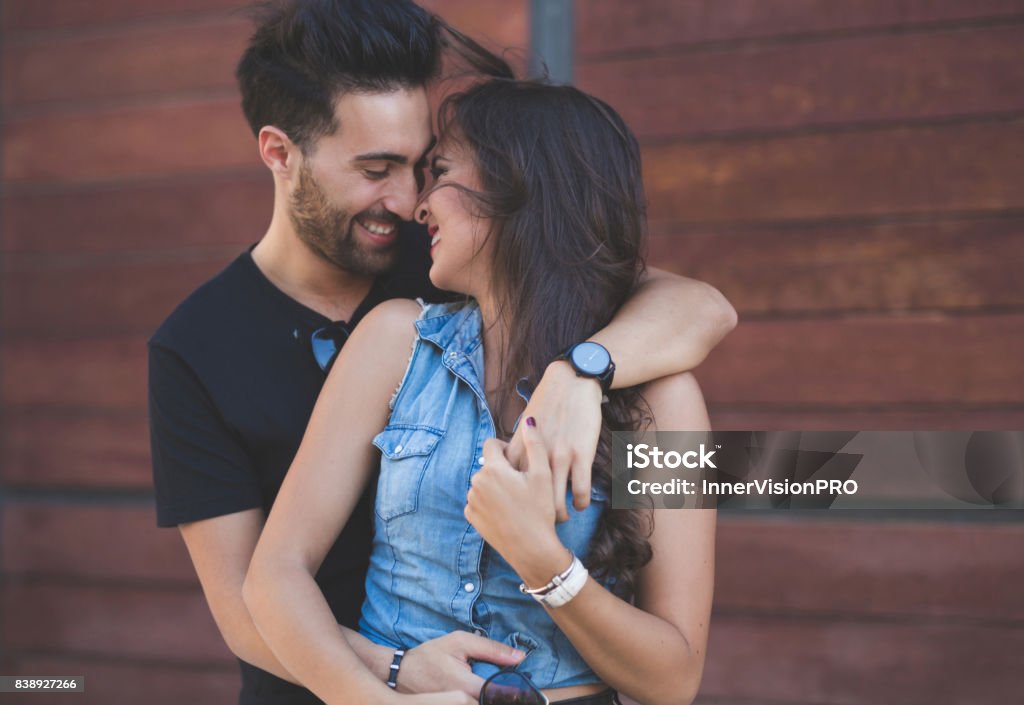 Couple cuddling together touching each other nose laughing Portrait of couple cuddling together touching each other nose laughing Couple - Relationship Stock Photo