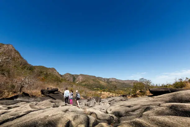 A DSLR Canon photo of a 3 generation family walking over the rocks on Vale da Lua (Moon Valley), Chapada dos Veadeiros (Veadeiros Plateau), Goiás, Brazil. Vale da Lua 