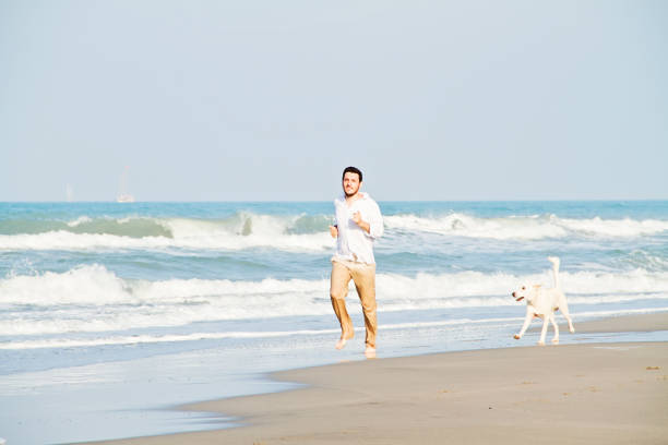 istock Man running with his dog on the beach 838937732
