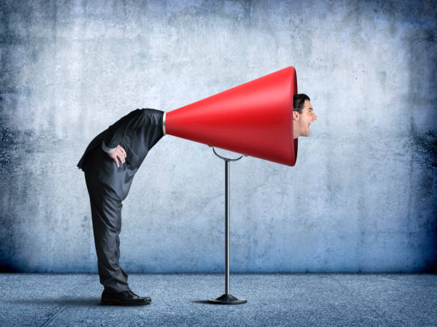 istock Businessman Sticks His Head Into A Large Red Megaphone 838940990
