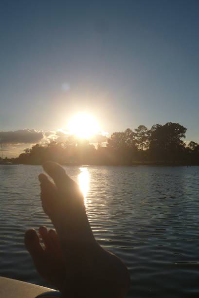 istock Sunset Clouds Trees Feet on Boat Water in background Chesepeake Bay 838955458
