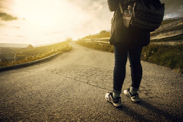 istock Woman is walking on the road at sunset 838962406