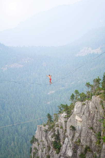 istock Man walking on highline - slackline over canyon at sunset 838966886