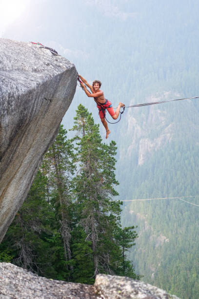 istock Man clinbing back on highline - slackline at sunset 838969420