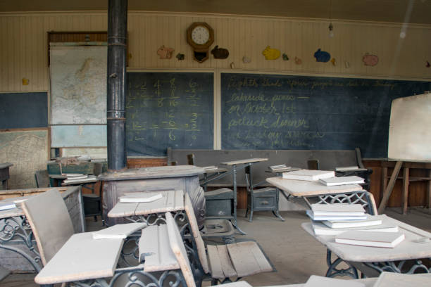 Antique desks in old schoolhouse with blackboard and books in Bodie State Historic Park,