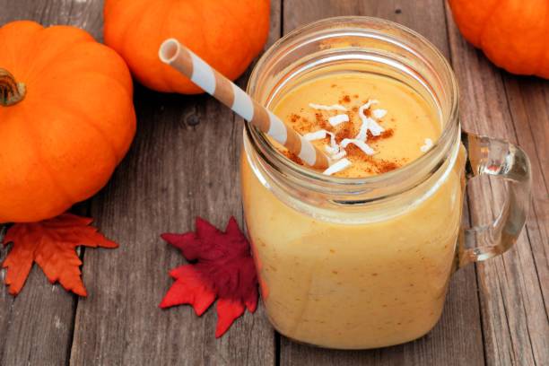 istock Pumpkin smoothie in a mason jar, scene on rustic wood 838978642