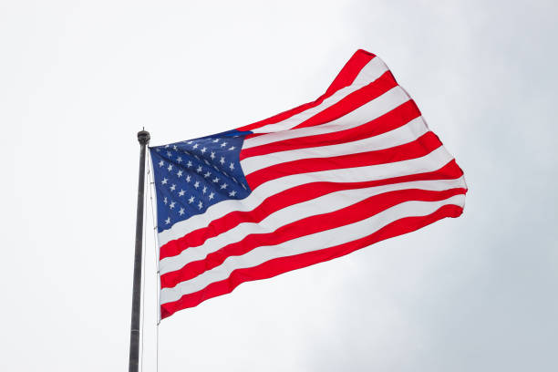 istock American Flag Blowing In Wind On Cloudy Day 838993950