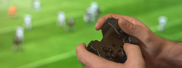istock Hand holding game controller playing football game. 839006954