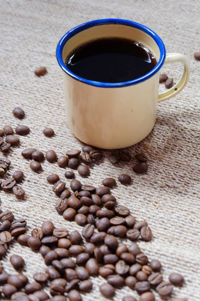 istock One enamel coffee cup and messy beans on vertical shot. 839008054