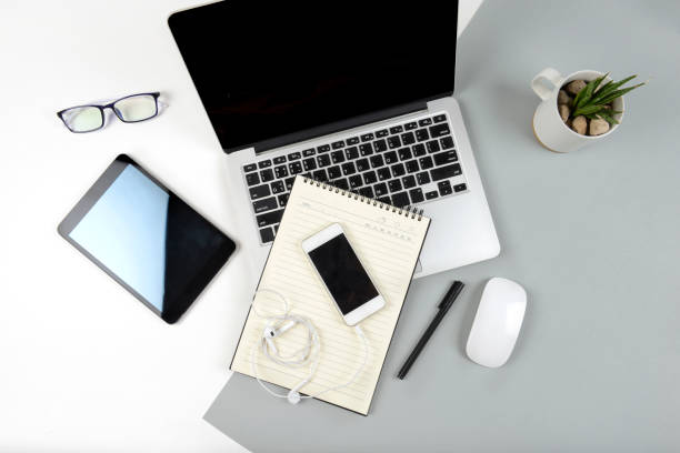 istock Office table with laptop computer, notebook, digital tablet and mobile phone on modern two tone (white and grey) background. 839017622
