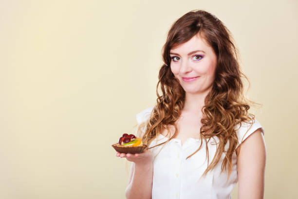 istock Smiling cute woman holds fruit cake in hand 839018230