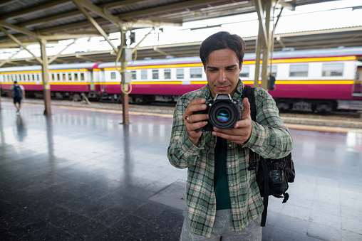 Portrait of handsome Persian tourist man at the railway station Hua Lamphong in Bangkok Thailand horizontal shot