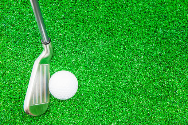 istock Golf ball and iron on artificial green grass detail macro 839032948