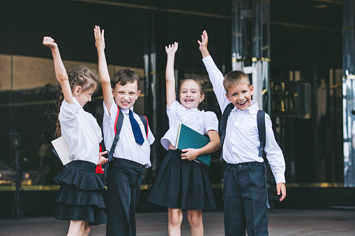 Hermosos niños activados y felices en el fondo de la escuela en uniforme photo