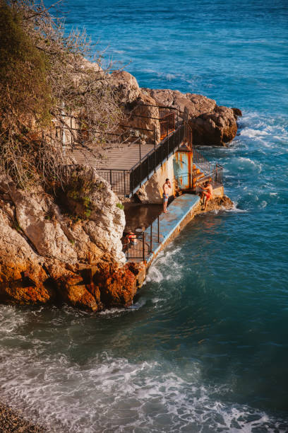 French Riviera in Nice 'Nice, France - June 15th, 2016: Two men swimming in the mediterranean sea in Nice,France. ivory coast landscape stock pictures, royalty-free photos & images