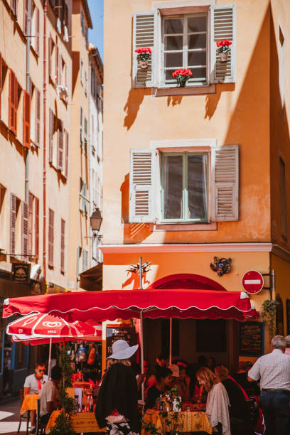 Sidewalk restaurants in Nice 'Nice, France - June 20th, 2016 : Tourists walking past/enjoying nice food in the old town of Nice, southern France. nice france restaurant stock pictures, royalty-free photos & images