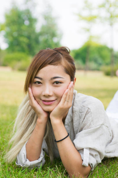 istock Asian young woman on the grass 839044324