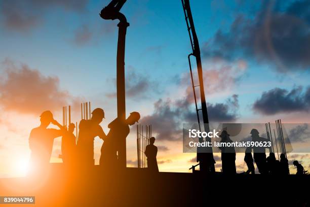 Silhouette Construction Industry Team In Modo Sicuro Per Lavorare Caricare La Costruzione Di Calcestruzzo In Base Allobiettivo Impostato Su Sfondo Sfocato Tramonto Pastello Per Lo Sfondo Del Settore - Fotografie stock e altre immagini di Industria