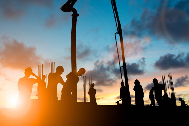 istock Silhouette construction industry team safely to work load concrete building according to set goal over blurred background sunset pastel for industry background. 839044796