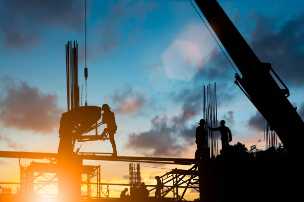 istock Silhouette construction industry team safely to work load concrete building according to set goal over blurred background sunset pastel for industry background. 839045058