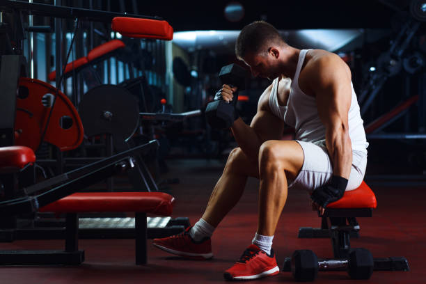 istock Young man exercising with weight in the gym. 839065054