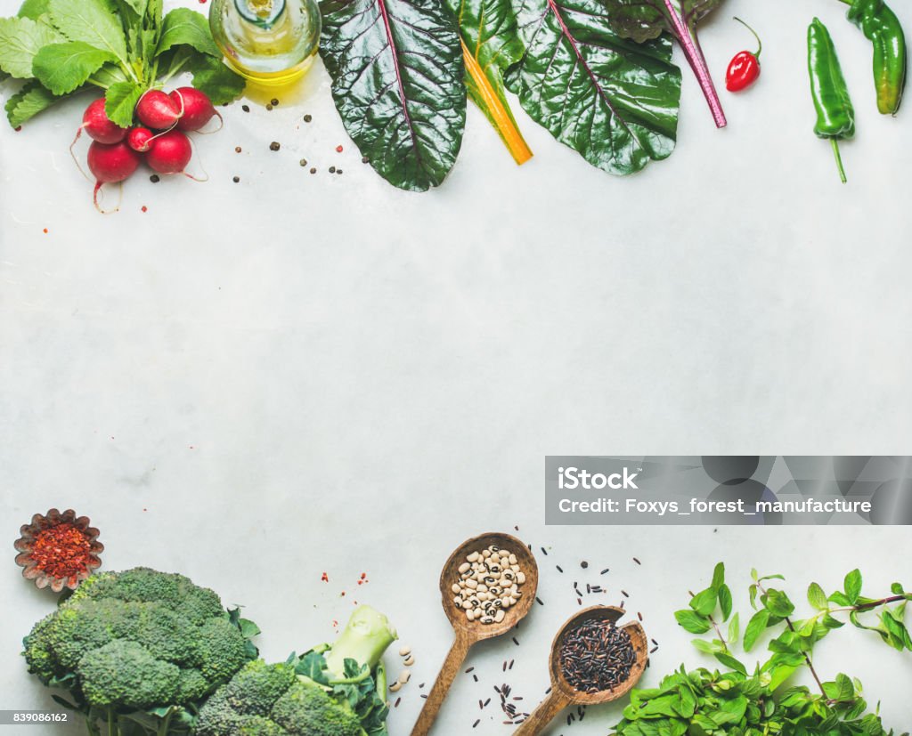 Fresh raw greens, vegetables and grains, copy space Fresh raw greens, unprocessed vegetables and grains over light grey marble kitchen countertop, top view, copy space. Clean eating, healthy, vegan, vegetarian, detox, dieting food concept Backgrounds Stock Photo