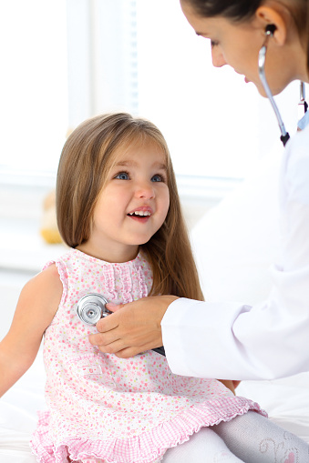 Doctor examining a little girl by stethoscope. Medicine and health care.