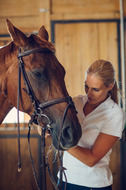 istock Woman in a barn with her horse 839105282