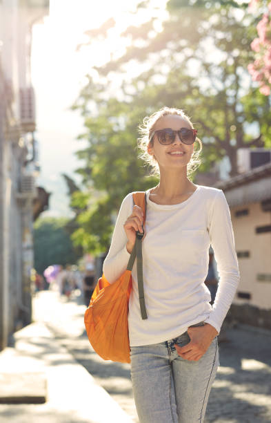 istock young cheerful woman with small orange packpack 839113564