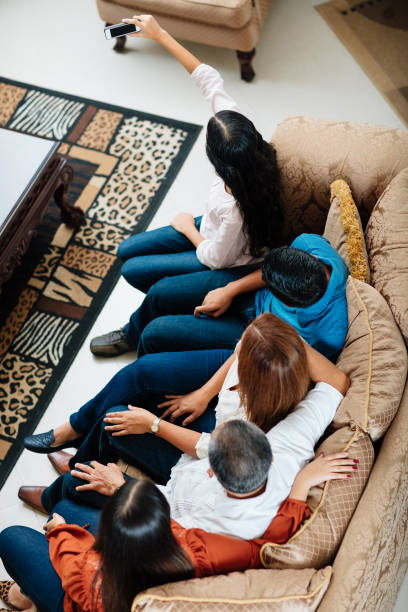 istock Mexican family sitting on sofa and taking selfie 839120702