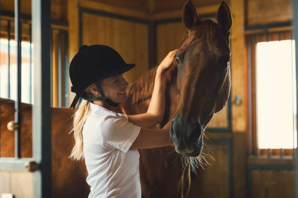 istock Woman in a barn stroking her horse 839121074