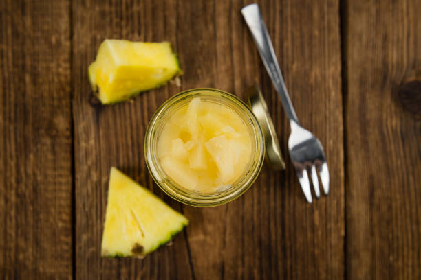 Fresh made Chopped Pineapple (preserved) on an old and rustic wooden table; selective focus; close-up shot