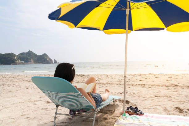 istock Woman Reading Book At Beach 839143426