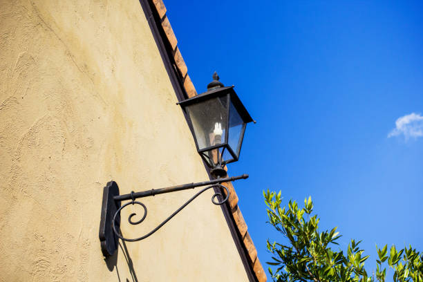 istock Classic iron hanging lamp on the cement wall with blue sky 839150144