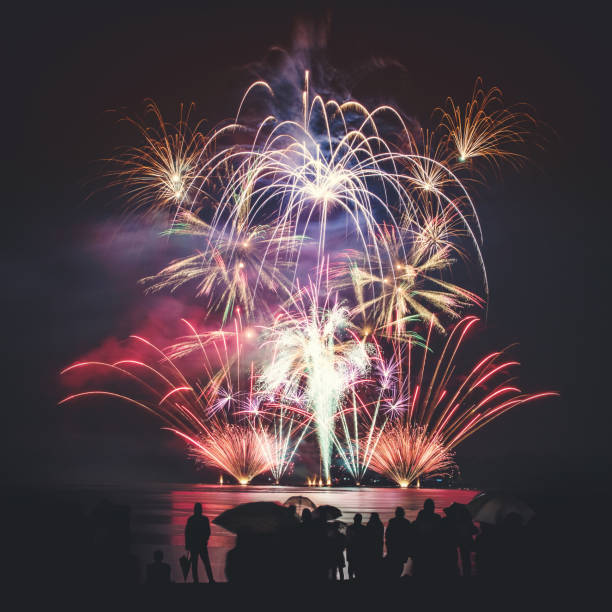 istock Beautiful large and colorful fireworks with unrecognizable crowd silhouettes people watching the show 839151050