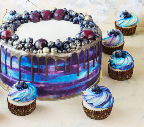 istock Bright festive blue cake with berries and chocolate and cupcakes with cream 839165774