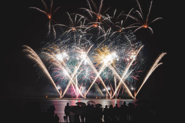 istock Beautiful large and colorful fireworks with unrecognizable crowd silhouettes people watching the show 839166012