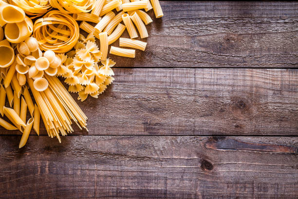 istock Various types of raw pasta on rustic wooden table with copy space 839169280