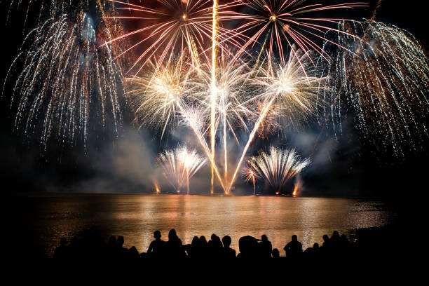 istock Beautiful large and colorful fireworks with unrecognizable crowd silhouettes people watching the show 839170346